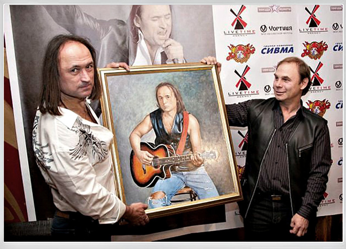 Художник Яков Пульнов вручает портрет юбиляру рок-музыканту Василию Акимову.