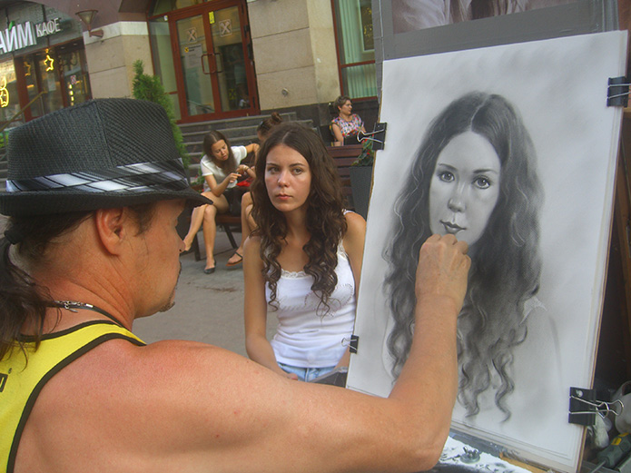 Руслан Кузнецов рисует портрет на Старом Арбате.